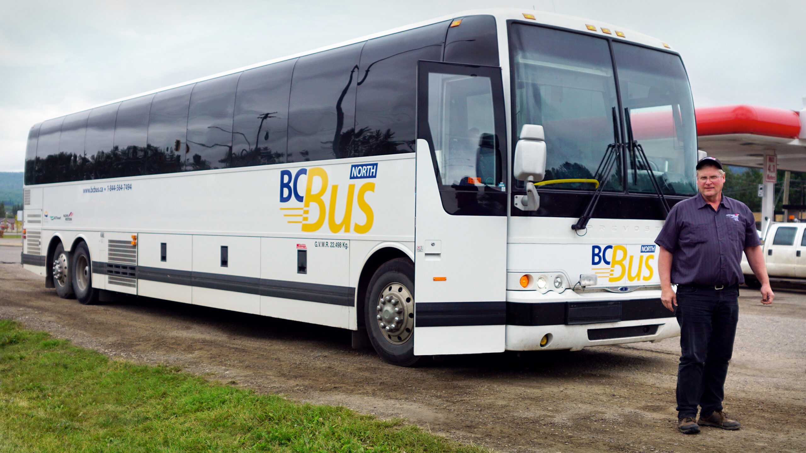 Driver standing in front of BC Bus North motorcoach.